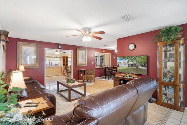 9414 Northcliffe Blvd, Spring Hill, FL 34606 - living room featuring ceiling fan, a textured ceiling, visible vents, light tile patterned flooring, and baseboards