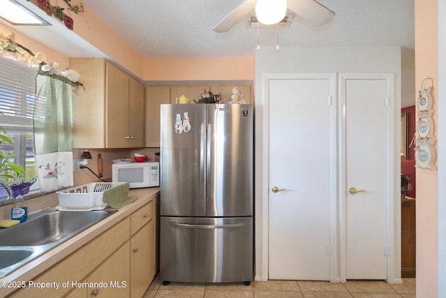 9414 Northcliffe Blvd, Spring Hill, FL 34606 - kitchen featuring light tile patterned flooring, white microwave, freestanding refrigerator, and a sink