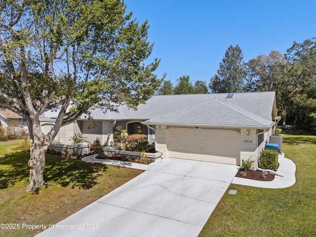 5232 Kirkwood Ave, Spring Hill, FL 34608 - ranch-style house featuring a garage, a front lawn, concrete driveway, and a shingled roof