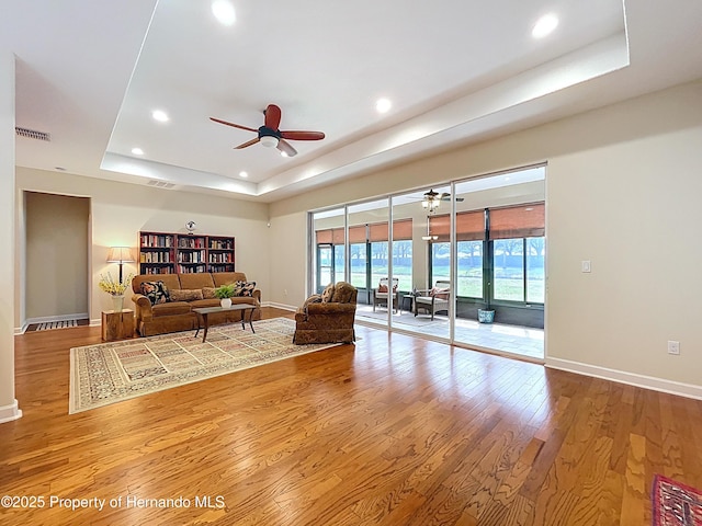 5401 Cappleman Loop, Brooksville, FL 34601 - living room with a tray ceiling, recessed lighting, wood finished floors, a ceiling fan, and baseboards