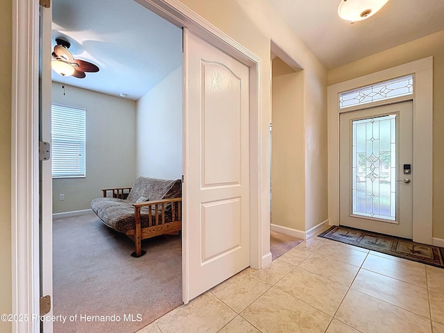 5401 Cappleman Loop, Brooksville, FL 34601 - foyer with baseboards, light tile patterned floors, ceiling fan, and light carpet