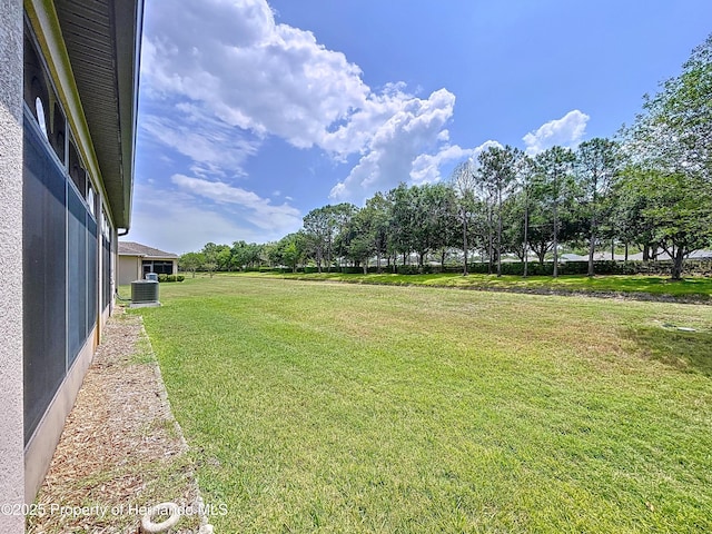5401 Cappleman Loop, Brooksville, FL 34601 - view of green lawn featuring central AC unit and view of scattered trees