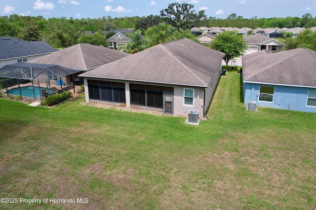 5401 Cappleman Loop, Brooksville, FL 34601 - rear view of house with a lawn, an outdoor pool, central AC, a residential view, and roof with shingles