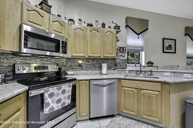 10109 Holly Berry Dr, Weeki Wachee, FL 34613 - kitchen with tasteful backsplash, light tile patterned floors, a sink, appliances with stainless steel finishes, and a peninsula
