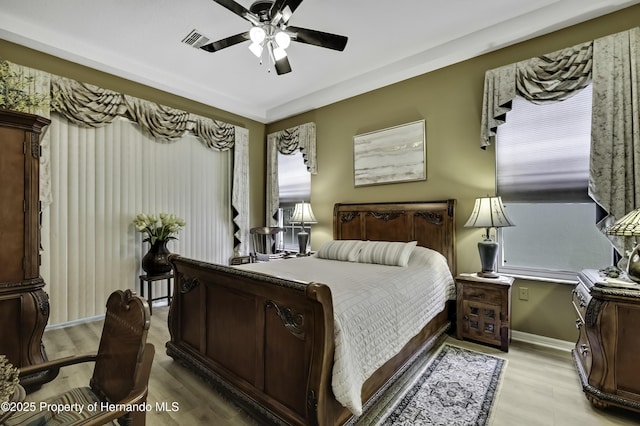 10109 Holly Berry Dr, Weeki Wachee, FL 34613 - bedroom with visible vents, light wood-style flooring, ceiling fan, and baseboards