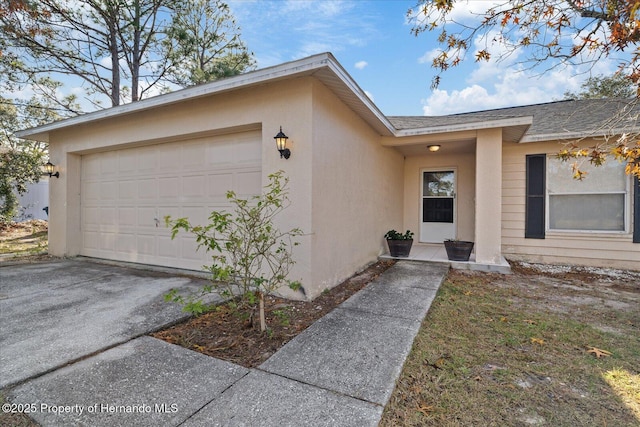 12575 Maleo Rd, Weeki Wachee, FL 34614 - doorway to property with a shingled roof, stucco siding, an attached garage, and driveway