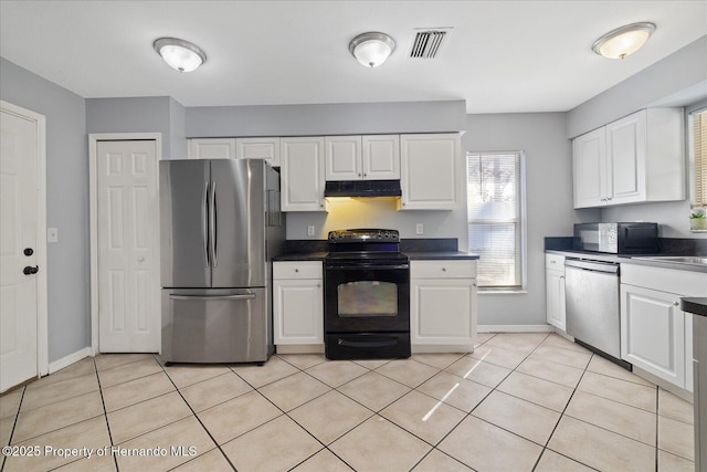 12575 Maleo Rd, Weeki Wachee, FL 34614 - kitchen with black appliances, under cabinet range hood, white cabinetry, light tile patterned flooring, and dark countertops