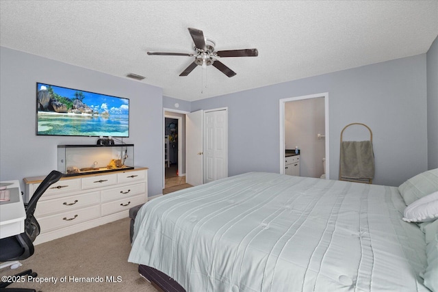 12575 Maleo Rd, Weeki Wachee, FL 34614 - bedroom with carpet, a textured ceiling, ceiling fan, and connected bathroom