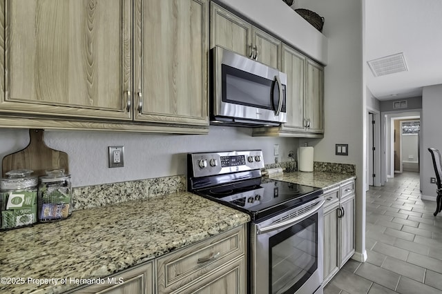 17364 Mediterranean Cir, Brooksville, FL 34614 - kitchen featuring tile patterned flooring, light stone countertops, visible vents, and appliances with stainless steel finishes