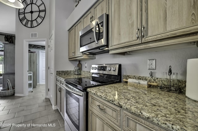 17364 Mediterranean Cir, Brooksville, FL 34614 - kitchen featuring visible vents, appliances with stainless steel finishes, light tile patterned floors, and light stone countertops
