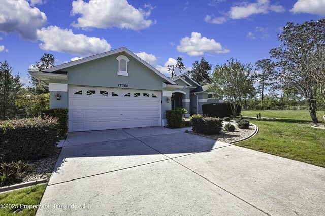 17364 Mediterranean Cir, Brooksville, FL 34614 - single story home with driveway, stucco siding, a front lawn, and a garage