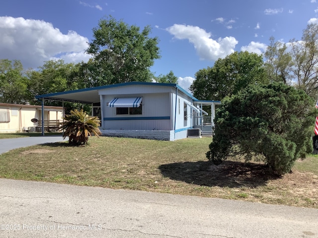 view of front of house with a front yard, an attached carport, and concrete driveway