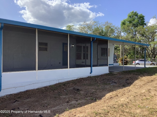 back of property with a sunroom