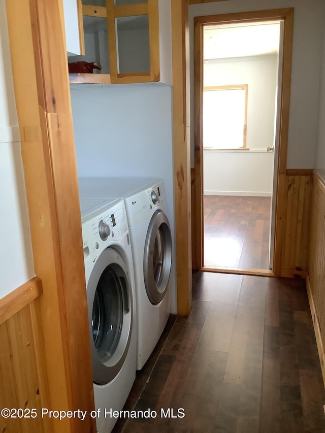clothes washing area featuring laundry area, independent washer and dryer, wainscoting, wood walls, and tile patterned floors
