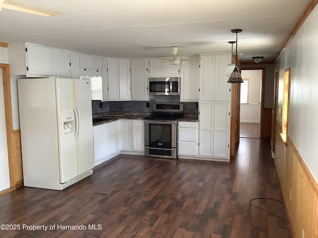 kitchen with dark wood-style flooring, dark countertops, and stainless steel appliances