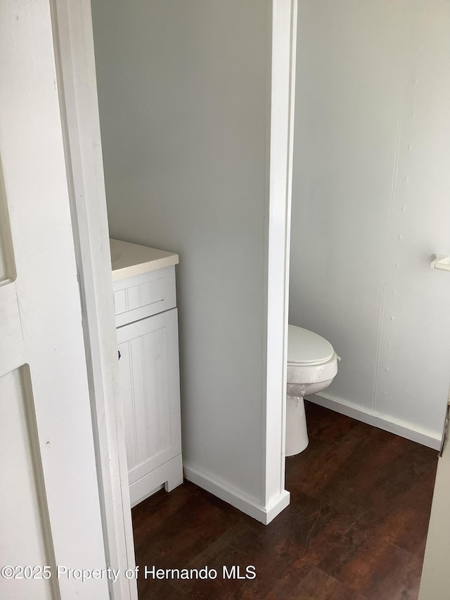 bathroom featuring toilet, wood finished floors, and baseboards