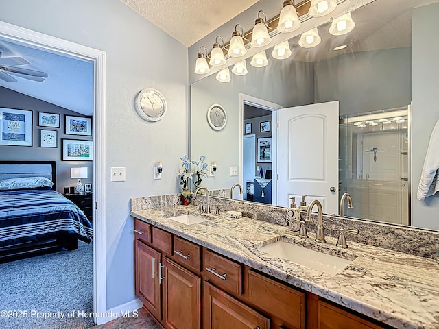 bathroom featuring a shower stall, vaulted ceiling, a textured ceiling, and a sink