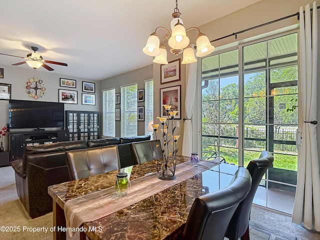 dining space with ceiling fan with notable chandelier and a healthy amount of sunlight