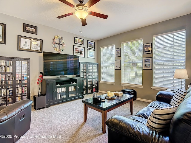 carpeted living room with ceiling fan and baseboards