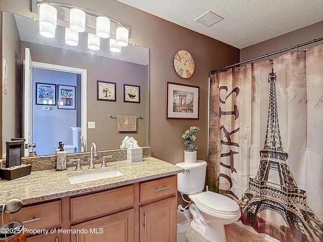 bathroom with visible vents, toilet, a textured ceiling, vanity, and tile patterned flooring