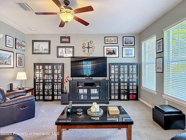 carpeted living room featuring visible vents, baseboards, and ceiling fan