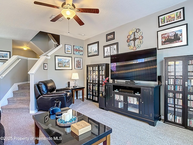 living area with baseboards, a ceiling fan, and carpet