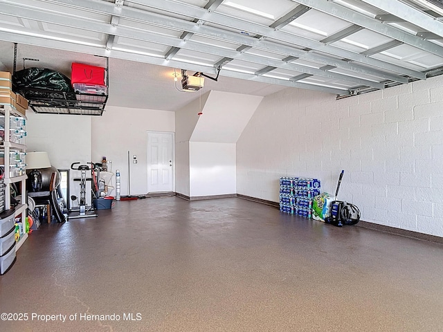 garage featuring a garage door opener, baseboards, and concrete block wall