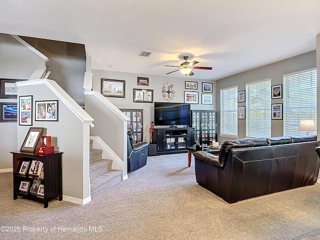 living room featuring visible vents, a ceiling fan, plenty of natural light, and carpet floors