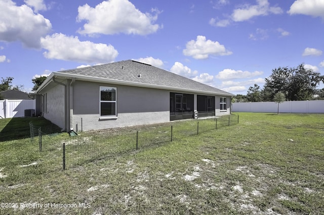 12848 Hilary St, Spring Hill, FL 34609 - back of house with a fenced backyard, a shingled roof, a lawn, and stucco siding
