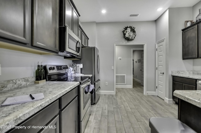 12848 Hilary St, Spring Hill, FL 34609 - kitchen with visible vents, light wood-type flooring, appliances with stainless steel finishes, and baseboards