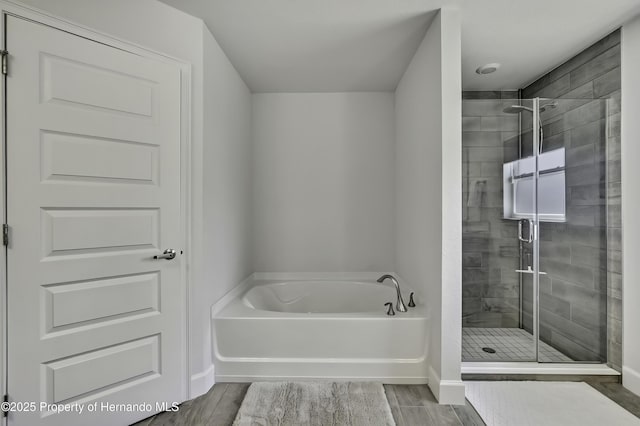 12848 Hilary St, Spring Hill, FL 34609 - bathroom with baseboards, a stall shower, wood finished floors, and a garden tub