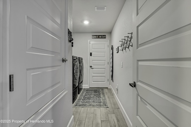 12848 Hilary St, Spring Hill, FL 34609 - doorway to outside with visible vents, washer and clothes dryer, light wood finished floors, and baseboards
