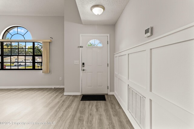 4405 Plumosa St, Spring Hill, FL 34607 - entrance foyer with baseboards, a textured ceiling, visible vents, and light wood-type flooring