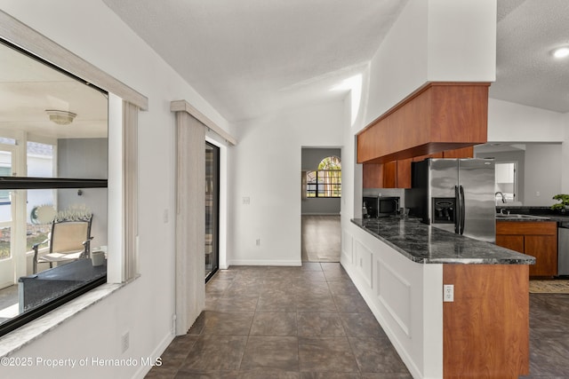 4405 Plumosa St, Spring Hill, FL 34607 - kitchen with vaulted ceiling, brown cabinetry, stainless steel appliances, and a sink