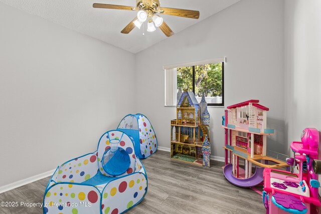 4405 Plumosa St, Spring Hill, FL 34607 - playroom featuring wood finished floors, vaulted ceiling, baseboards, and ceiling fan