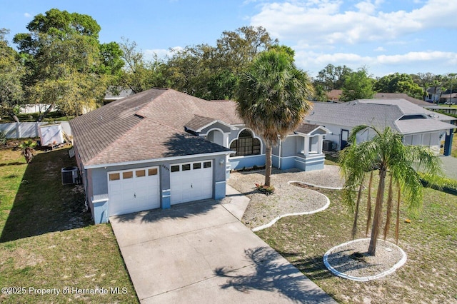4405 Plumosa St, Spring Hill, FL 34607 - ranch-style home with roof with shingles, central air condition unit, driveway, a garage, and stucco siding