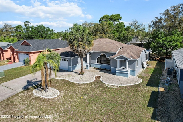 4405 Plumosa St, Spring Hill, FL 34607 - view of front of property featuring stucco siding, driveway, a front yard, and a garage