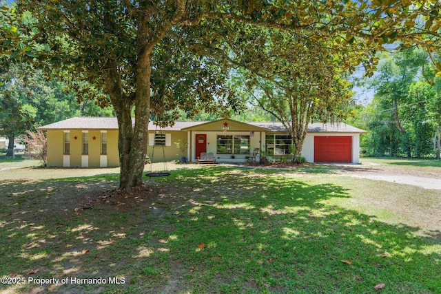 ranch-style home featuring driveway, a front yard, and a garage