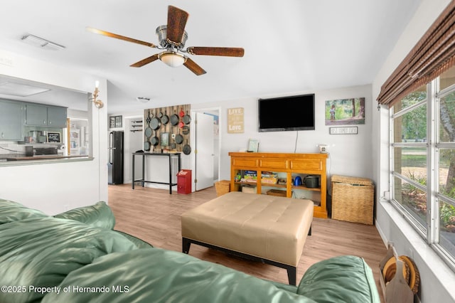 living room with a wealth of natural light, light wood finished floors, and visible vents