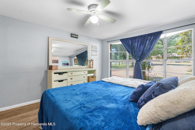 bedroom featuring baseboards, a ceiling fan, and wood finished floors