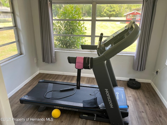 exercise area with wood finished floors and baseboards