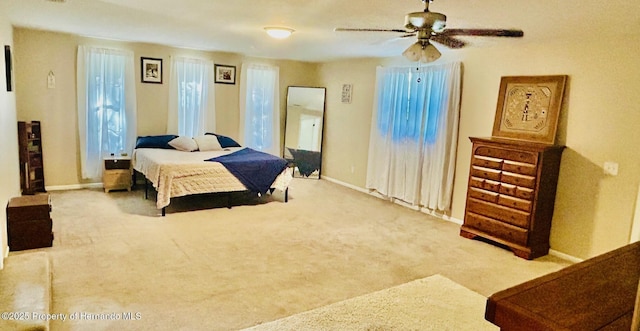 carpeted bedroom with baseboards and a ceiling fan