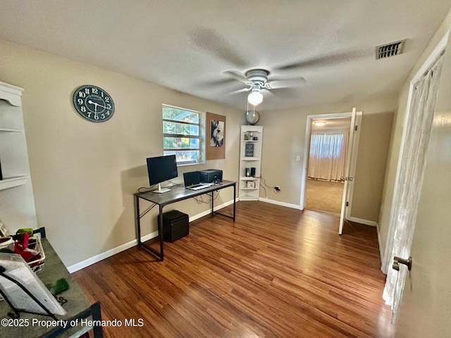 home office featuring wood finished floors, visible vents, baseboards, and ceiling fan