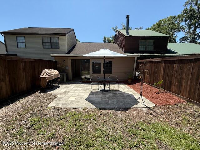 947 Village Dr, Brooksville, FL 34601 - back of property with a fenced backyard and a patio