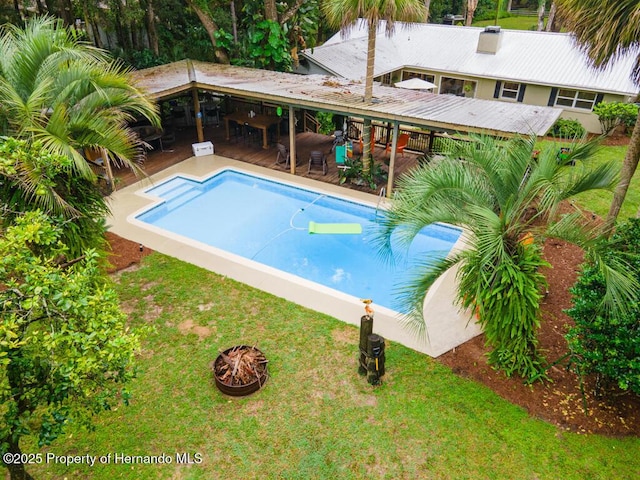 pool with a lawn, a fire pit, and a patio area
