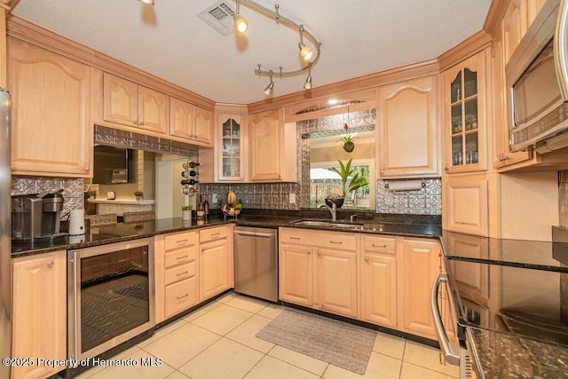 kitchen with light brown cabinetry, appliances with stainless steel finishes, a sink, and wine cooler
