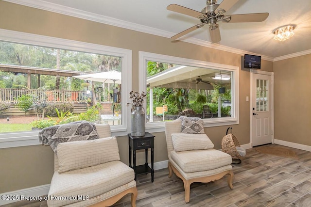 sunroom / solarium featuring a wooden deck, wood finished floors, baseboards, and crown molding