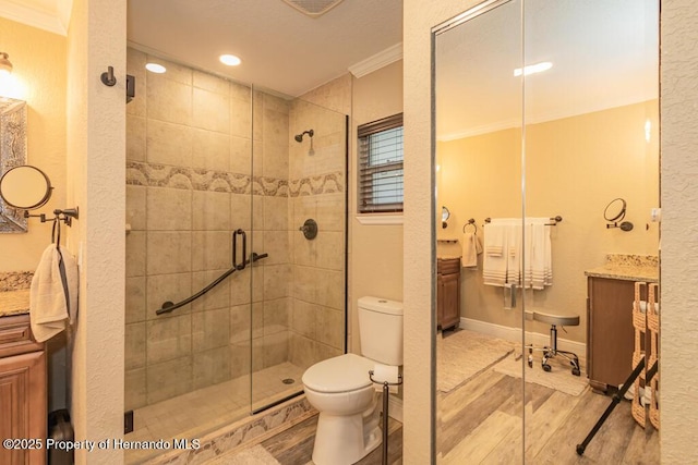 full bath with wood finished floors, a shower stall, ornamental molding, and toilet