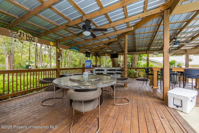 wooden terrace with outdoor dining area and ceiling fan