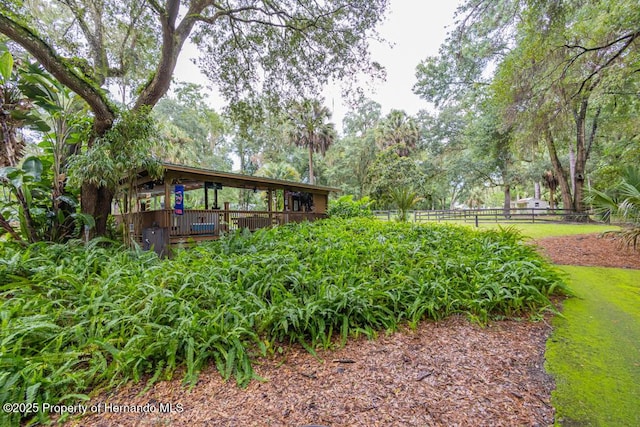 view of yard featuring a wooden deck and fence